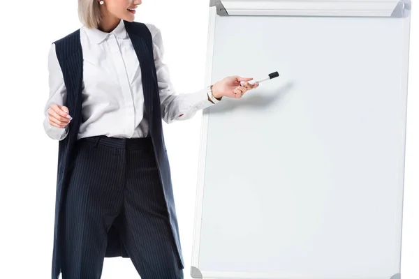 Vue partielle de femme d'affaires en tenue de cérémonie pointant vers le tableau blanc vide isolé sur blanc — Photo de stock