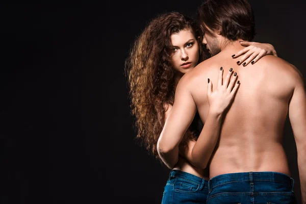 Rückseite der Freundin umarmt hemdlosen Mann isoliert auf schwarz — Stockfoto