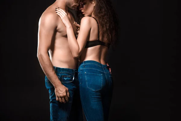 Частичный вид сексуальной пары без рубашки, обнимающей изолированных на черном — стоковое фото