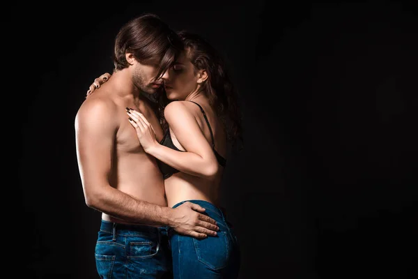 Side view of sexy shirtless couple hugging isolated on black — Stock Photo