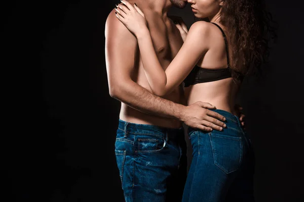 Partial view of sexy shirtless couple hugging isolated on black — Stock Photo