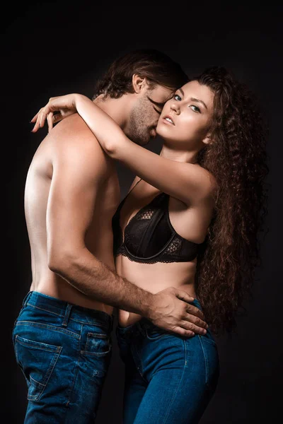 Side view of sexy shirtless couple hugging isolated on black — Stock Photo