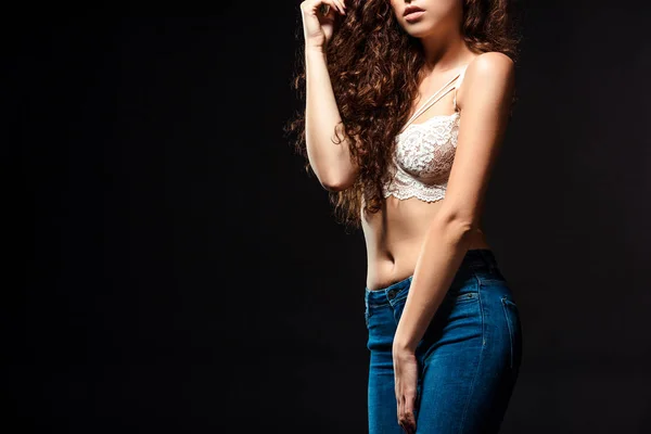 Partial view of woman in white bra and jeans posing isolated  on black — Stock Photo