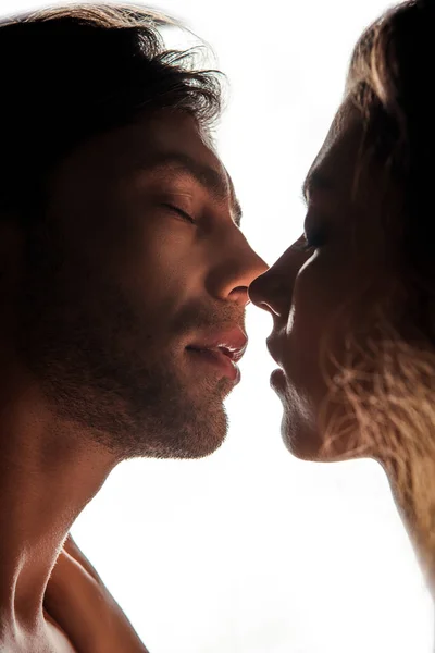 Vista lateral do casal beijando enquanto em pé cara a cara, isolado no branco — Fotografia de Stock