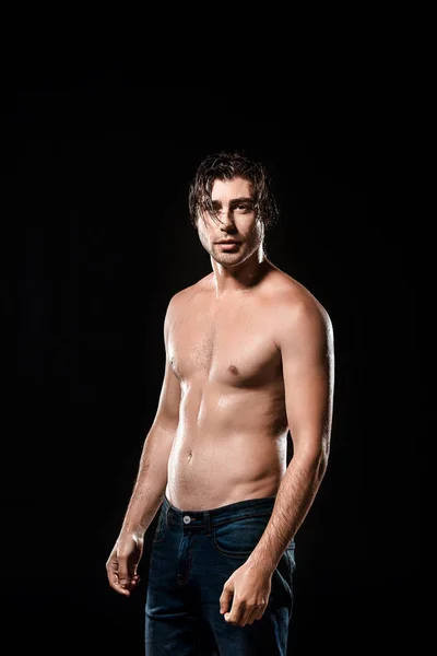 Ritratto di uomo senza camicia con i capelli bagnati in jeans isolati su nero — Foto stock