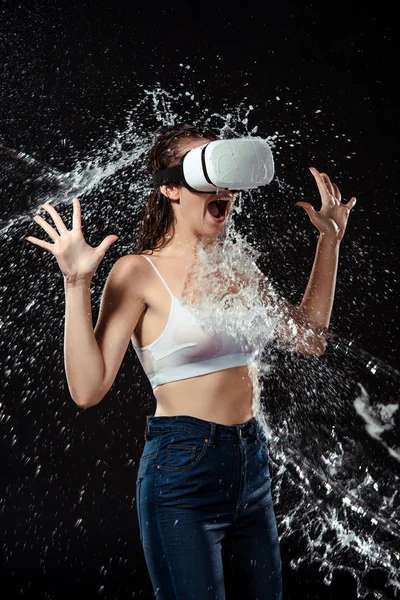 Emotionale Frau in vr Headset schwitzte mit Wasser isoliert auf schwarz — Stockfoto
