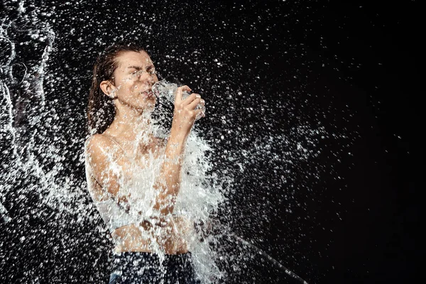 Side view of woman swilled with water while drinking water from glass isolated on black — Stock Photo