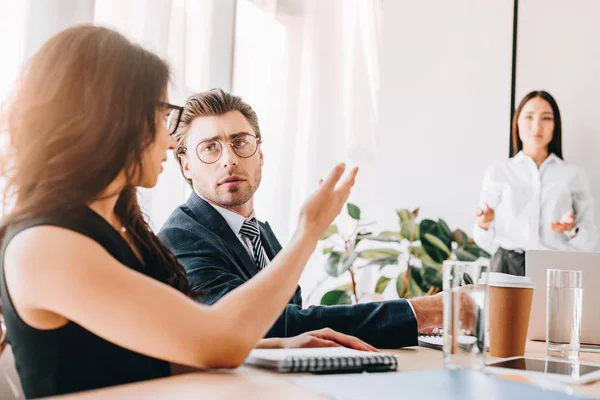 Enfoque selectivo de hombres de negocios y mujeres de negocios multirraciales que trabajan en el proyecto empresarial juntos en la oficina - foto de stock