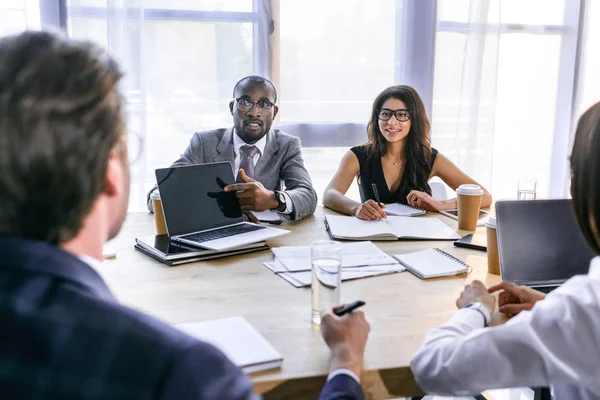 Selektiver Fokus einer Gruppe multiethnischer Geschäftskollegen, die während eines Geschäftstreffens im Büro über die Strategie diskutieren — Stockfoto