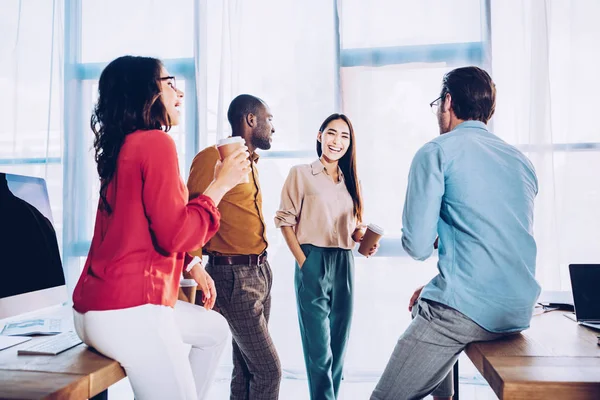 Colegas de negócios inter-raciais conversando durante coffee break no escritório — Fotografia de Stock