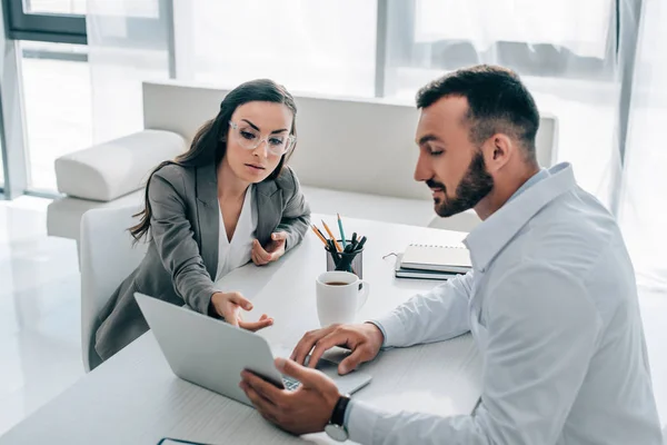 Patient pointing on laptop to general practitioner in clinic — Stock Photo