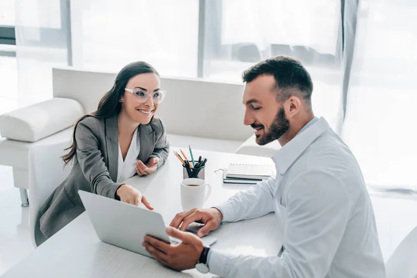 Paziente sorridente che punta sul computer portatile al medico in clinica — Foto stock