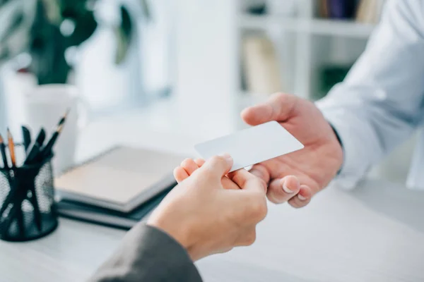 Cropped image of patient giving empty card to doctor in clinic — Stock Photo
