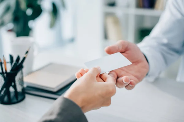 Geschnittenes Bild des Patienten, der dem Arzt in der Klinik eine leere Karte gibt — Stockfoto