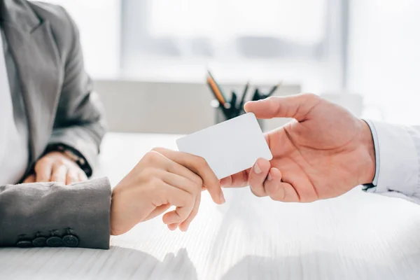 Cropped image of patient giving id card to doctor in clinic — Stock Photo