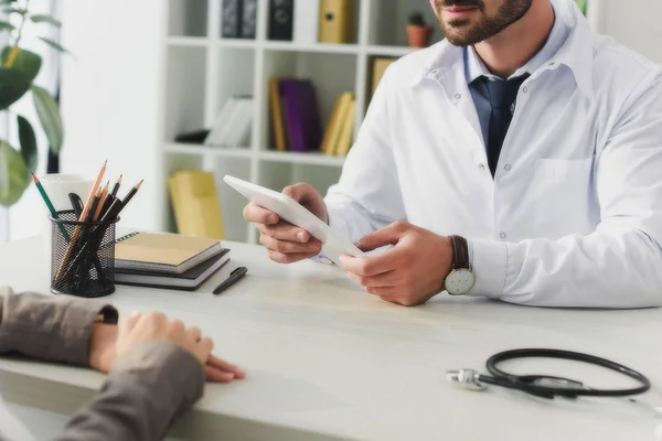 Обрезанное изображение врача, держащего таблетку в клинике — стоковое фото