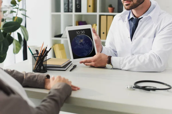Cropped image of general practitioner showing patient ipad in clinic — Stock Photo