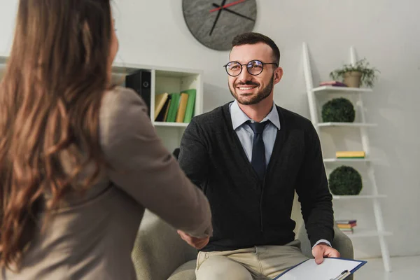 Happy psychologist and patient shaking hands in doctors office — Stock Photo