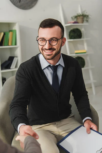 Patient of happy psychologist and patient shaking hands in doctors office — Stock Photo