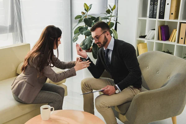 Patient showing smartphone to psychologist in doctors office — Stock Photo