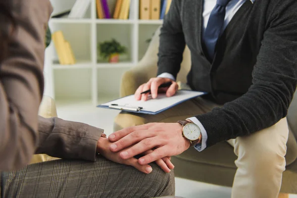 Cropped image of therapist touching hand of patient in doctors office — Stock Photo