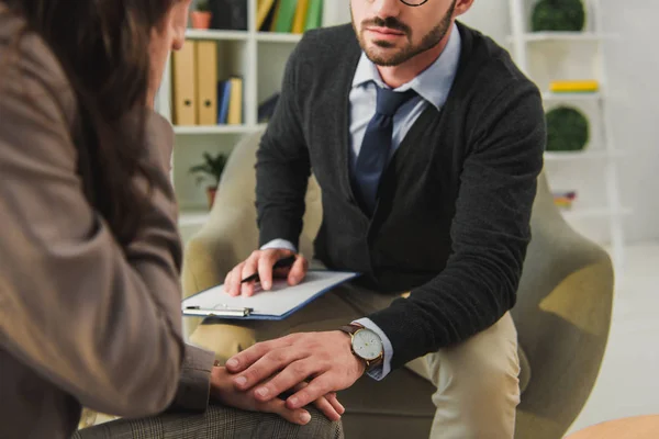 Imagen recortada de psicólogo tocando la mano del paciente en el consultorio médico - foto de stock