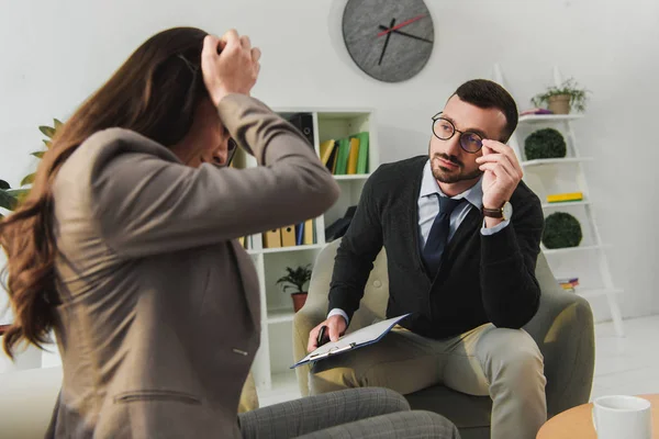 Depressed patient touching head in psychologist office — Stock Photo