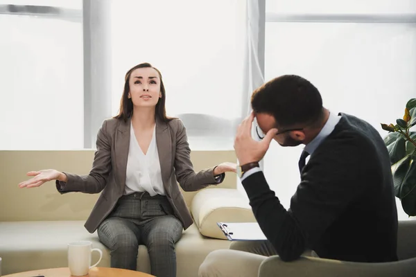 Depressed patient crying and gesturing in therapist office — Stock Photo