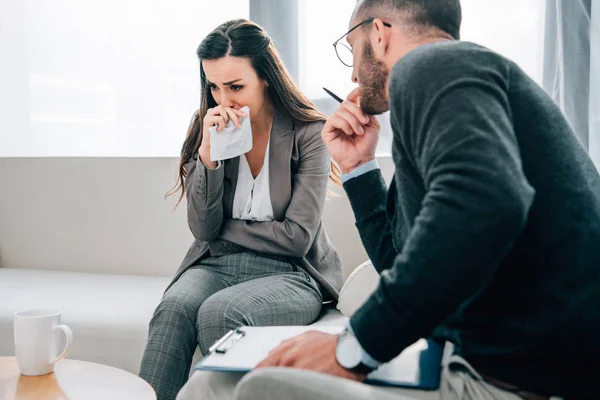 Paciente deprimido llorando en el consultorio del terapeuta - foto de stock