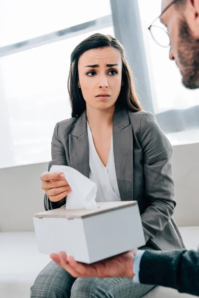 Psychologist giving napkins to upset patient in doctors office — Stock Photo