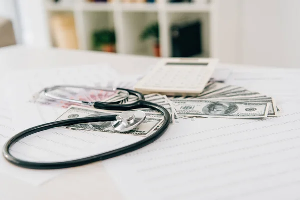 Stethoskop, Taschenrechner und Geldscheine auf dem Tisch in der Klinik, Krankenversicherungskonzept — Stockfoto