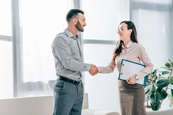 Smiling psychologist and patient shaking hands in office — Stock Photo