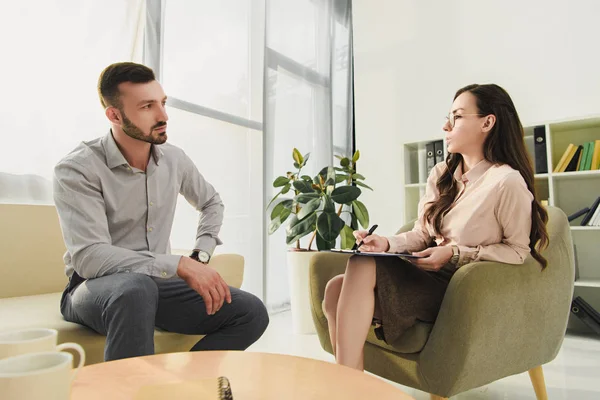 Professional psychologist talking with patient in office — Stock Photo