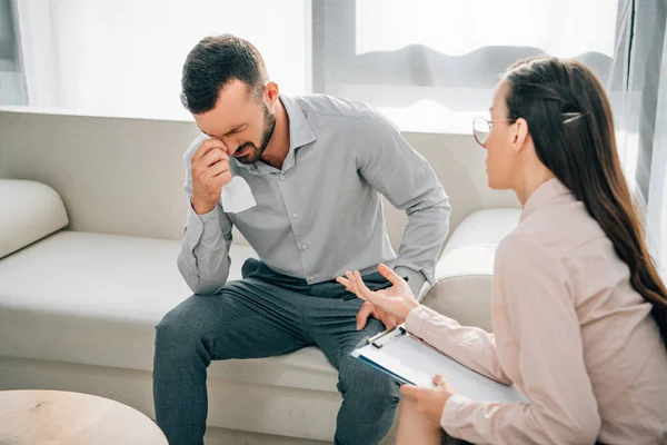 Psicologo con appunti che parla con il paziente in ufficio che piange — Foto stock