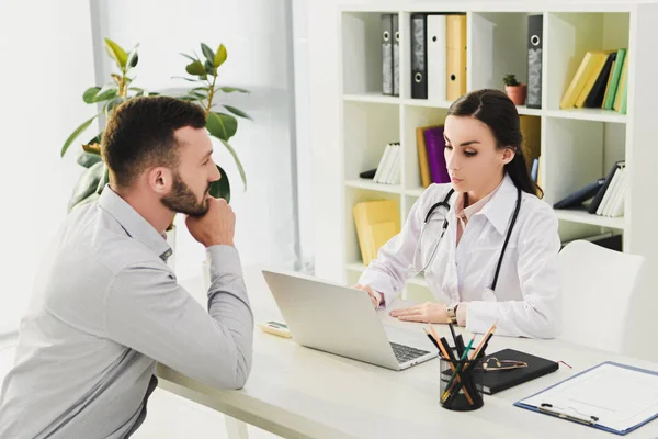 Client and doctor in medical office with laptop — Stock Photo