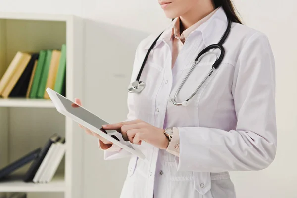 Vista recortada do médico de casaco branco com estetoscópio usando comprimido digital — Fotografia de Stock