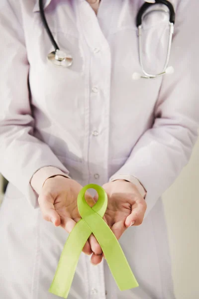 Частковий вид на лікаря в білому пальто, що тримає зелену стрічку день психічного здоров'я — стокове фото