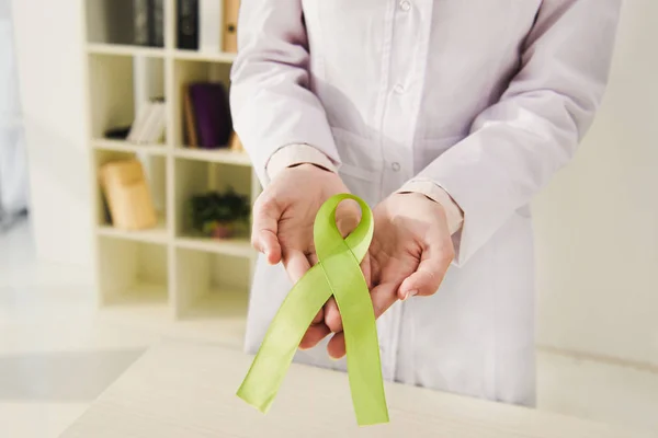 Обрізаний вид лікаря, який тримає зелену стрічку день психічного здоров'я — стокове фото