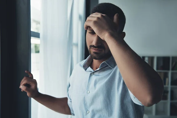 Hombre molesto que sufre de dolor de cabeza en casa - foto de stock