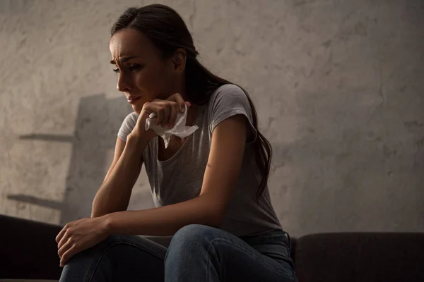 Mulher triste segurando guardanapo e chorando de tristeza e sentado em casa — Fotografia de Stock