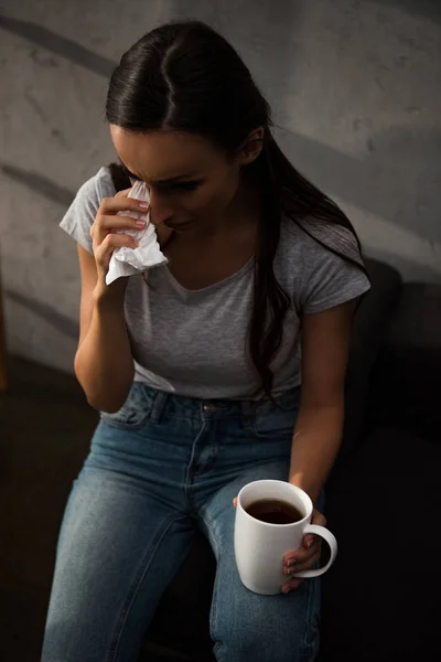 Upset woman crying and holding napkin and cup of coffee — Stock Photo