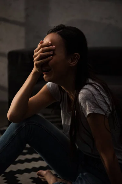 Эмоциональная женщина плачет в горе дома — стоковое фото