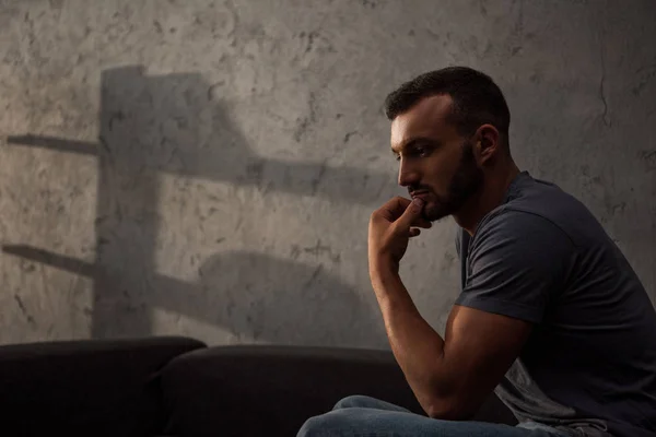 Lonely pensive man sitting on sofa at home — Stock Photo