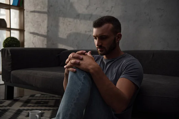 Solitario deprimido hombre sentado en casa - foto de stock