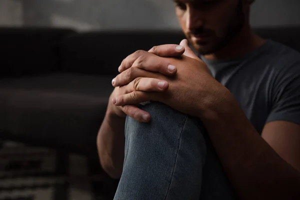 Uomo triste seduto sul pavimento a casa, messa a fuoco selettiva — Foto stock