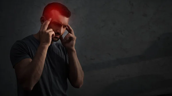 Втомлений засмучений чоловік, що страждає від головного болю з червоною болючою точкою на голові — стокове фото