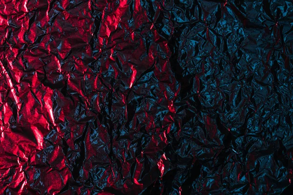 Brillante abstracto arrugado rojo y negro papel de aluminio de fondo - foto de stock