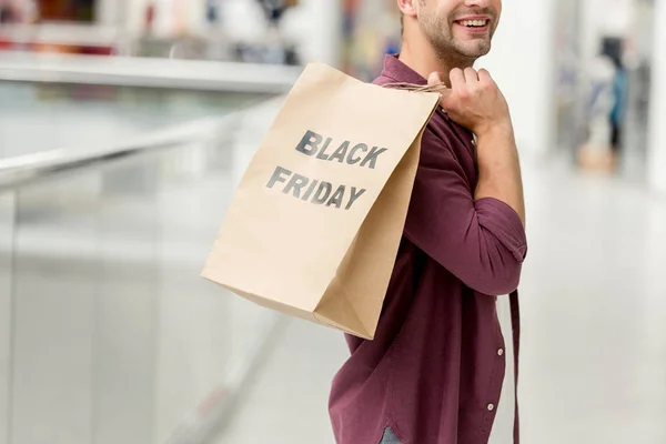Vista parcial del hombre sosteniendo papel con letras negro viernes en el centro comercial - foto de stock