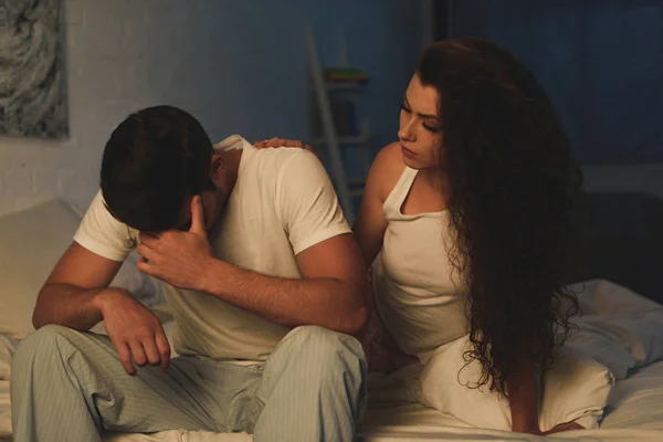 Fille regardant l'homme contrarié assis sur le lit la nuit, concept de difficultés relationnelles — Photo de stock