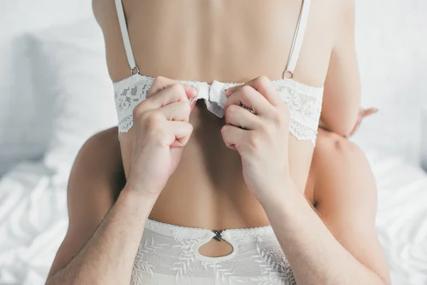 Vue arrière partielle de l'homme décoller soutien-gorge de petite amie sexy — Photo de stock